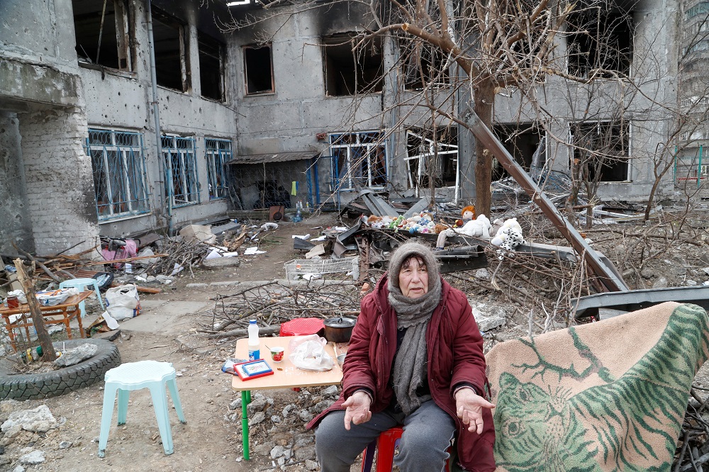 Local resident and pensioner Valentina Popyi, 75, who seeks refuge in a children’s home damaged in the course of Ukraine-Russia conflict, speaks with neighbours in the southern port city of Mariupol, Ukraine April 1, 2022. — Reuters pic