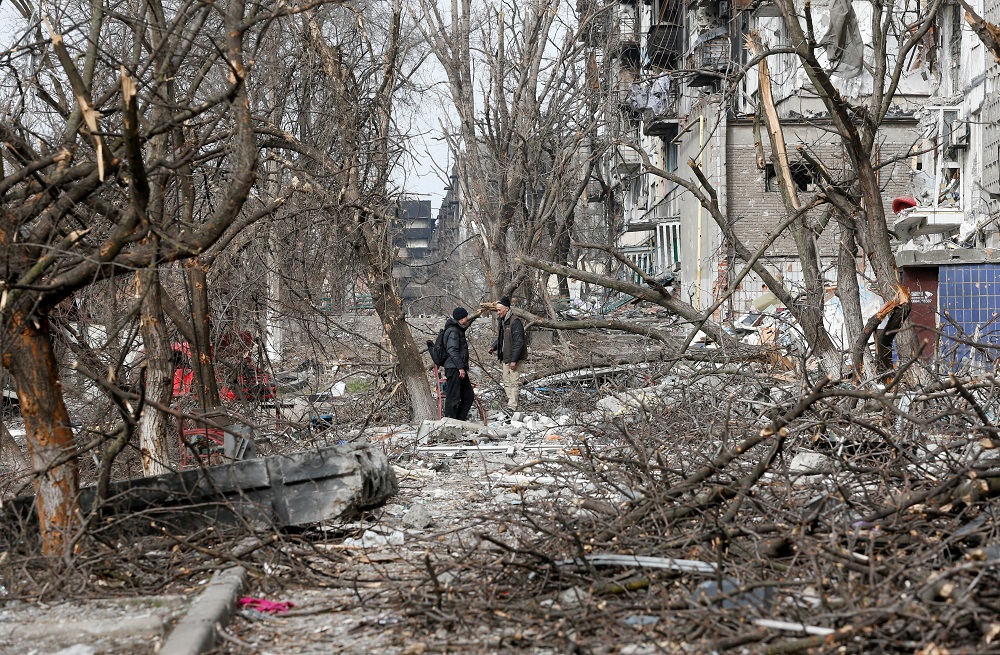 Men speak in a courtyard near a residential building damaged in the course of Ukraine-Russia conflict in the southern port city of Mariupol April 1, 2022. u00e2u20acu201d Reuters pic