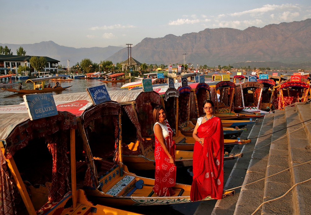 Tourists pose on parked ‘Shikaras’ or boats on the banks of Dal Lake in Srinagar April 5, 2022. — Reuters pic