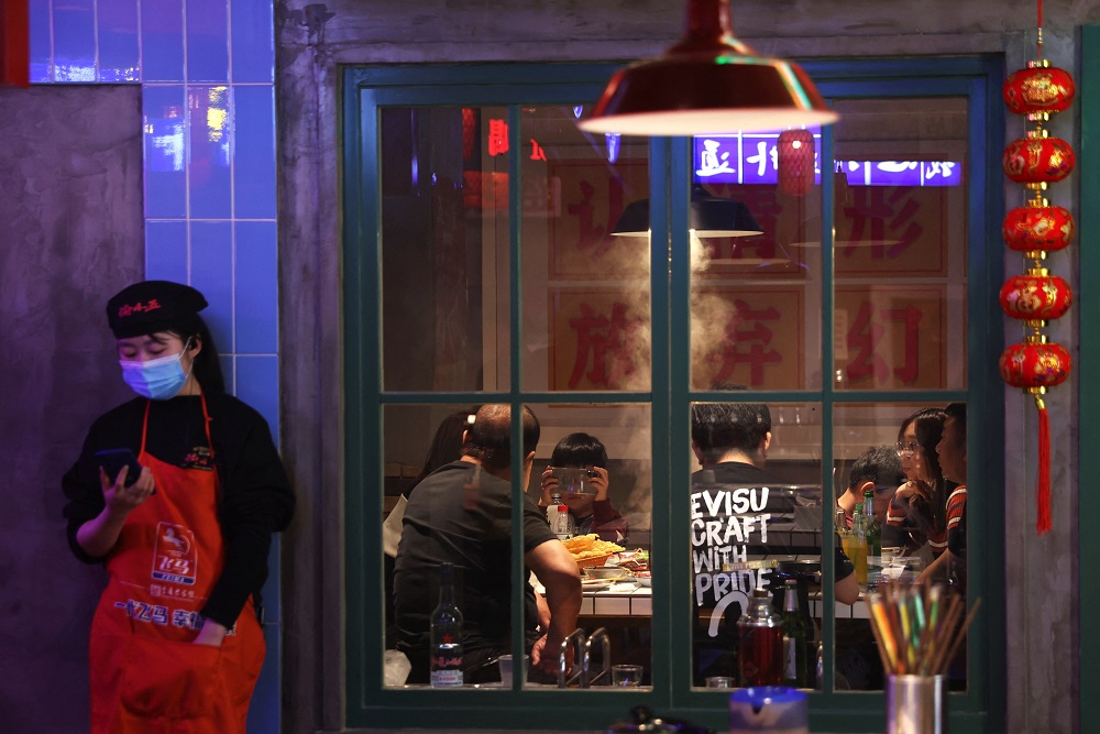 A staff member stands outside of a room where people dine at a hotpot restaurant in Beijing April 8, 2022. u00e2u20acu201d Reuters pic