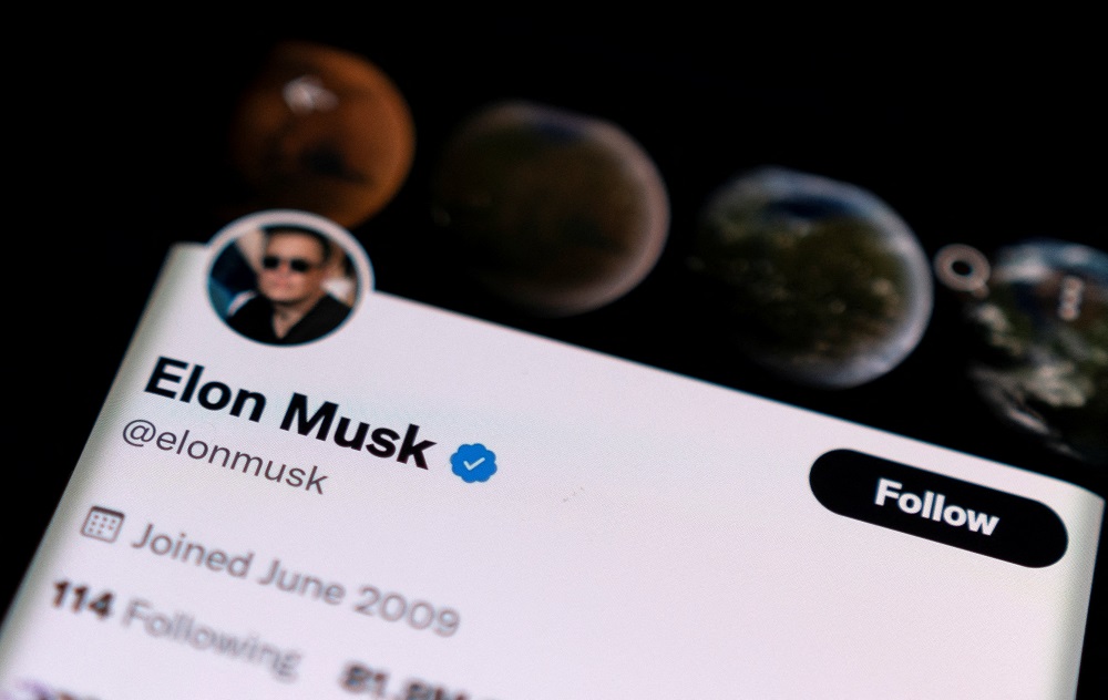 Elon Musku00e2u20acu2122s twitter account is seen on a smartphone in front of the Twitter logo in this photo illustration taken, April 15, 2022. u00e2u20acu201d Reuters pic