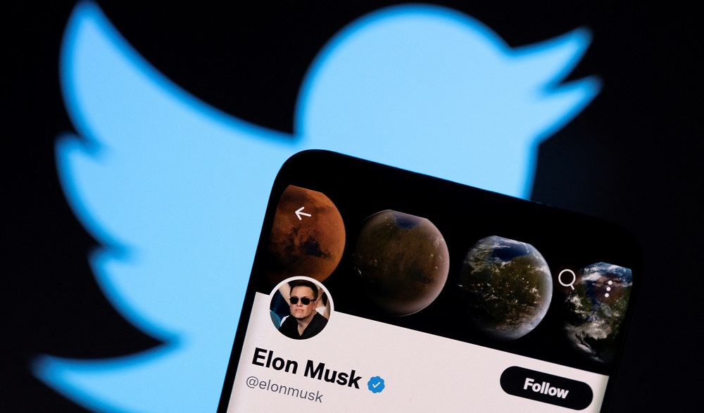 Elon Musku00e2u20acu2122s twitter account is seen on a smartphone in front of the Twitter logo in this photo illustration taken, April 15, 2022. u00e2u20acu201d Reuters pic