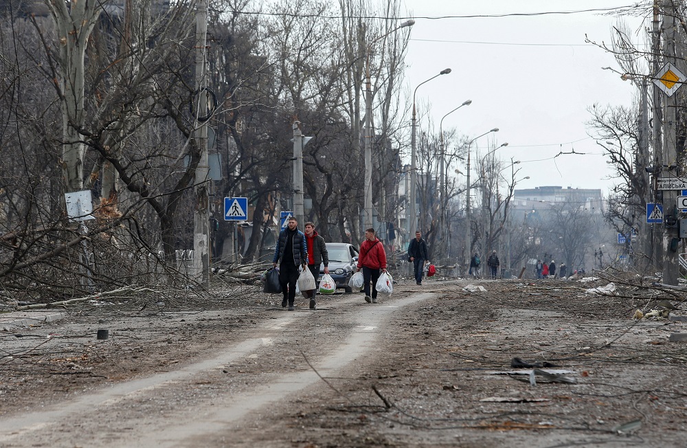 People walk along a street, which was damaged during Ukraine-Russia conflict in the southern port city of Mariupol, Ukraine April 17, 2022. u00e2u20acu201d Reuters pic