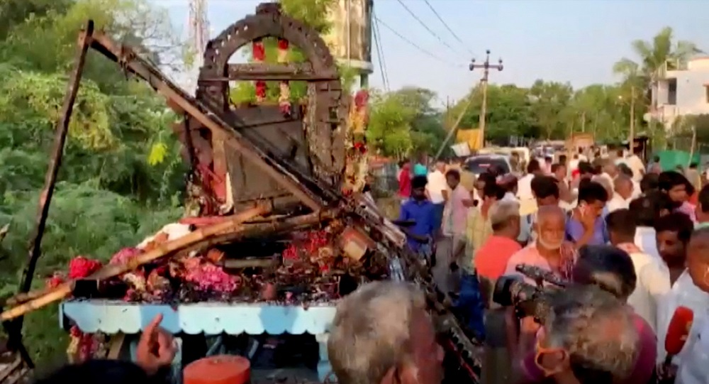 People gather around a chariot that was damaged after a high voltage power wire fell on it during a procession in a temple festival in Kalimedu village, Thanjavur district, India April 27, 2022. u00e2u20acu201d Still image obtained from video by ANI via Reuters