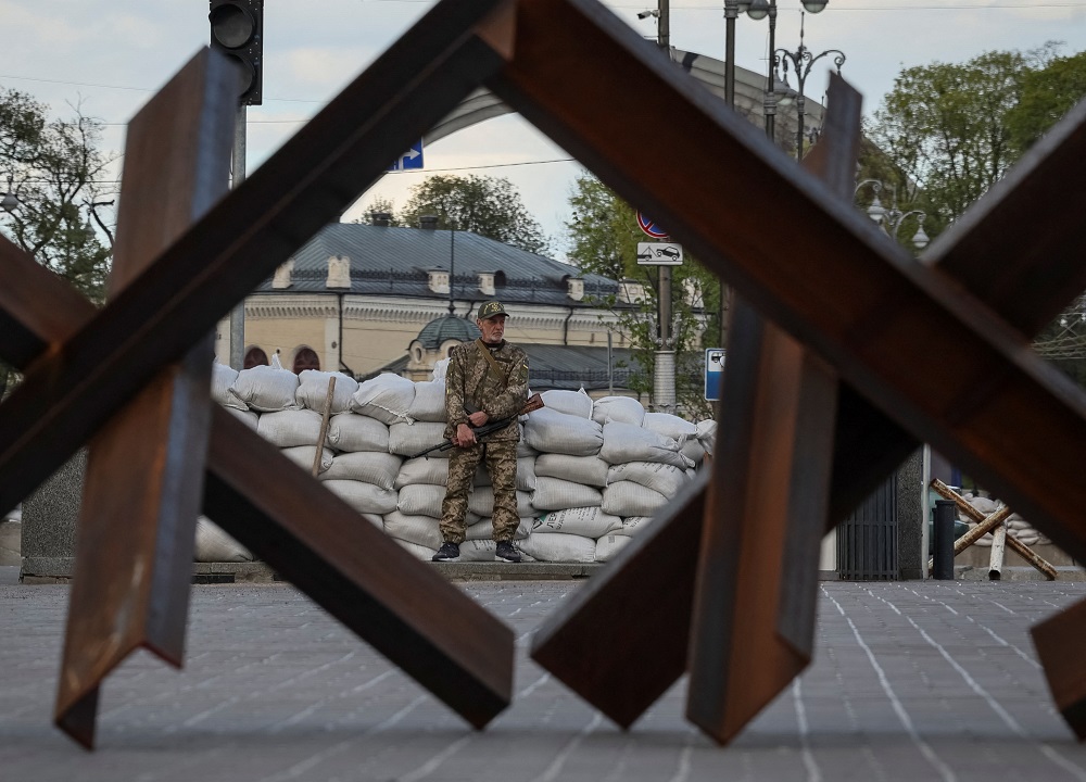 A serviceman stands guard next to anti-tank constructions, amid Russia's invasion of Ukraine, in central Kyiv April 28, 2022. — Reuters pic