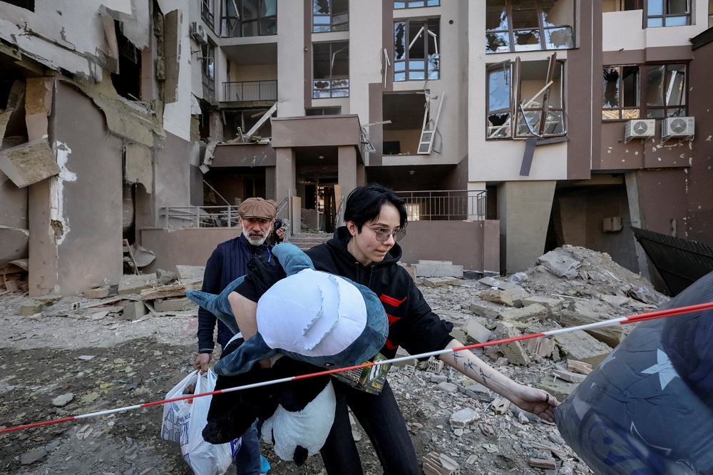 Local residents leave their apartment building which was destroyed in a military strike, amid Russia's invasion of Ukraine, in Kyiv April 29, 2022. — Reuters pic