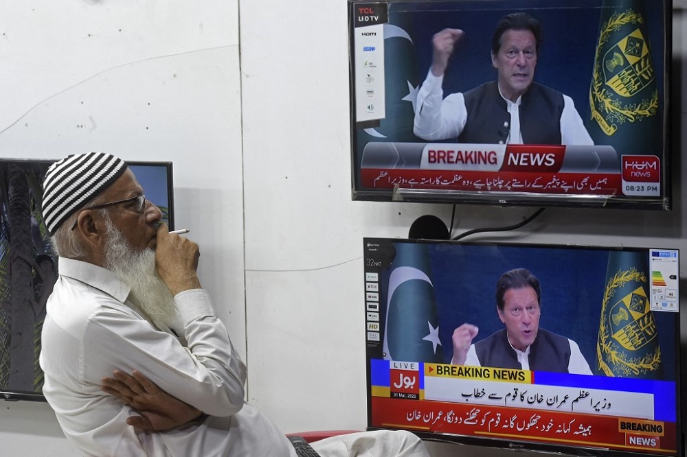 A man listens to Pakistan's Prime Minister Imran Khan addressing the nation on television at a market in Karachi March 31, 2022. u00e2u20acu201d AFP pic