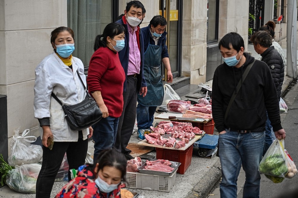 Vendors sell meat on a street in front of a local market in Jingu00e2u20acu2122an district, in Shanghai March 31, 2022. u00e2u20acu201d AFP pic