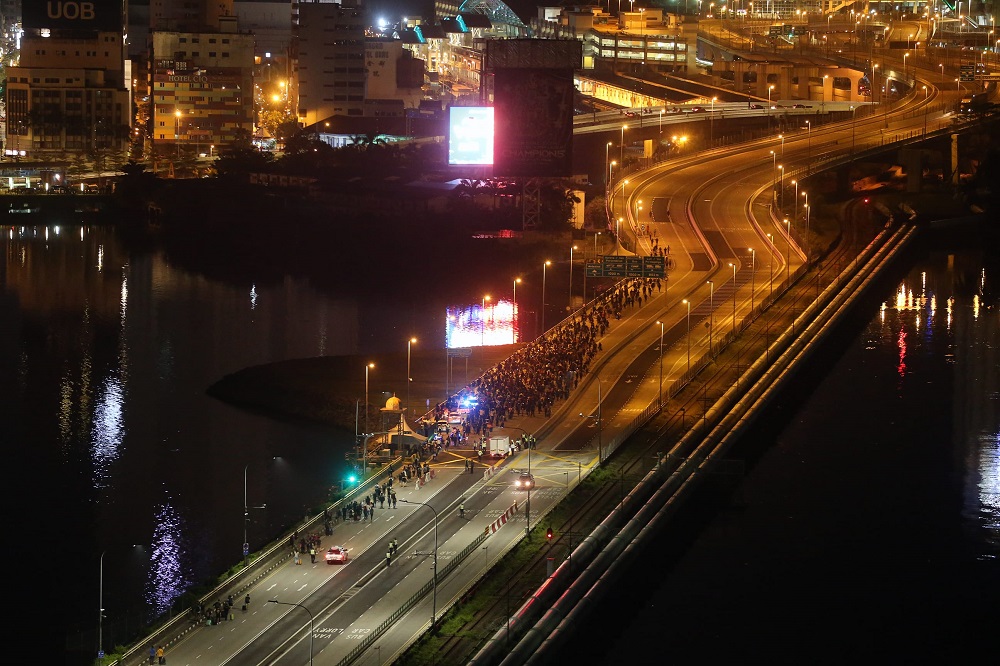 Pedestrians and motorcyclists making their way across the Causeway from Singapore to Malaysia in the early hours of April 1, 2022. — TODAY pic
