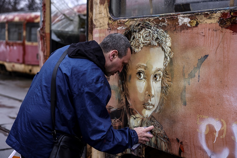 French street-artist Christian Guemy, known as C215, paints one of his works next to a metro station and food market that were badly damaged by a Russian strike in Kyiv. u00e2u20acu201d AFP pic