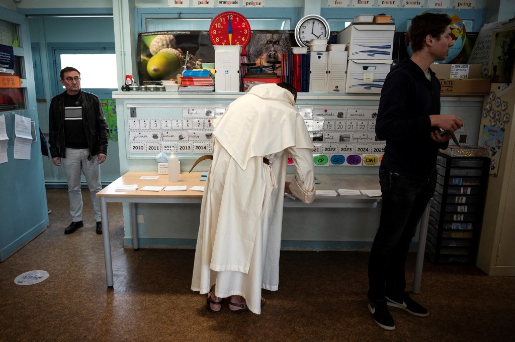 A clergyman takes ballots before voting for the first round of France's presidential election at a polling station in Toulouse, southwestern France on April 10, 2022. u00e2u20acu201d AFP picnn