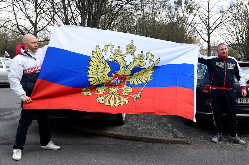 Two men hold a Russian flag as pro-Russia supporters gather to take part in a motorcade in Hanover, Germany, April 10, 2022.  u00e2u20acu201d Reuters pic