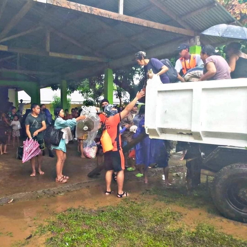A rescuer assists people to get down from a vehicle, after the tropical storm Megi hit, in Capiz Province, Philippines April 12, 2022. u00e2u20acu201d Philippine Coast Guard/Handout via Reuters pic