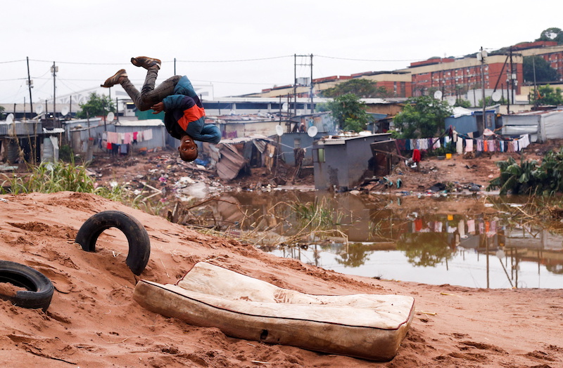 A child does a back flip onto an old mattress among the destruction caused by flooding in Umlazi near Durban, South Africa, April 16, 2022. u00e2u20acu201d Reuters picnn