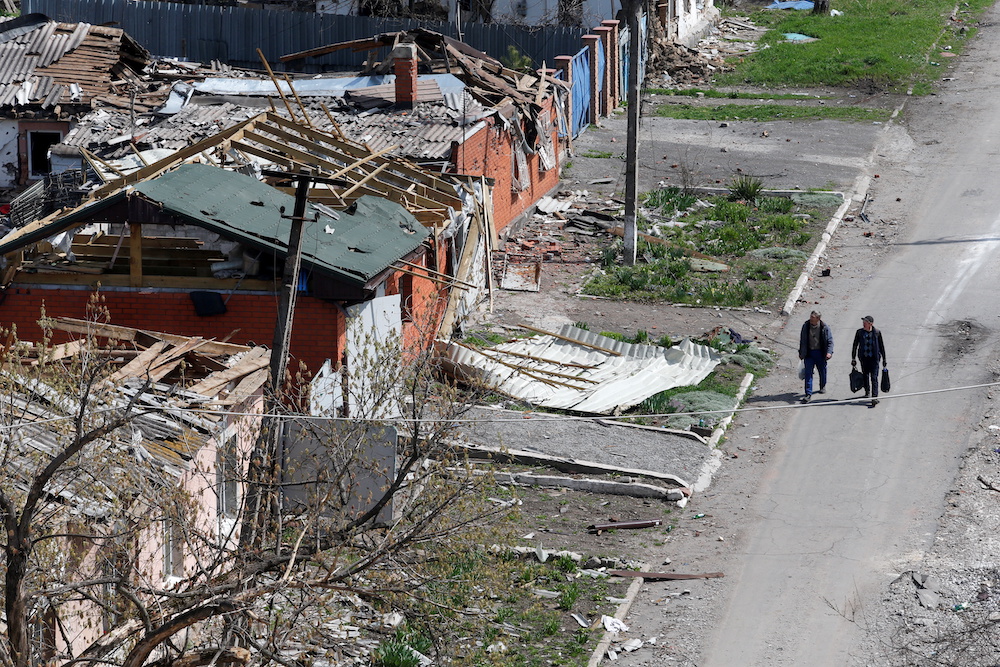 People walk near buildings damaged in the course of Ukraine-Russia conflict in the southern port city of Mariupol, Ukraine April 18, 2022. u00e2u20acu201d Reuters pic