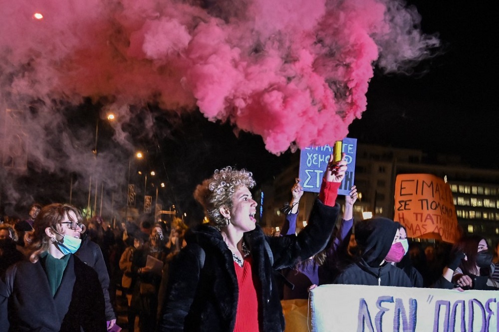 A woman hold a flare as others hold placards, one of them reading u00e2u20acu02dcwe are full of rageu00e2u20acu2122 during a demonstration in support of victims of rape and abuse and calling for justice, in Athens January 21, 2022. u00e2u20acu201d AFP pic
