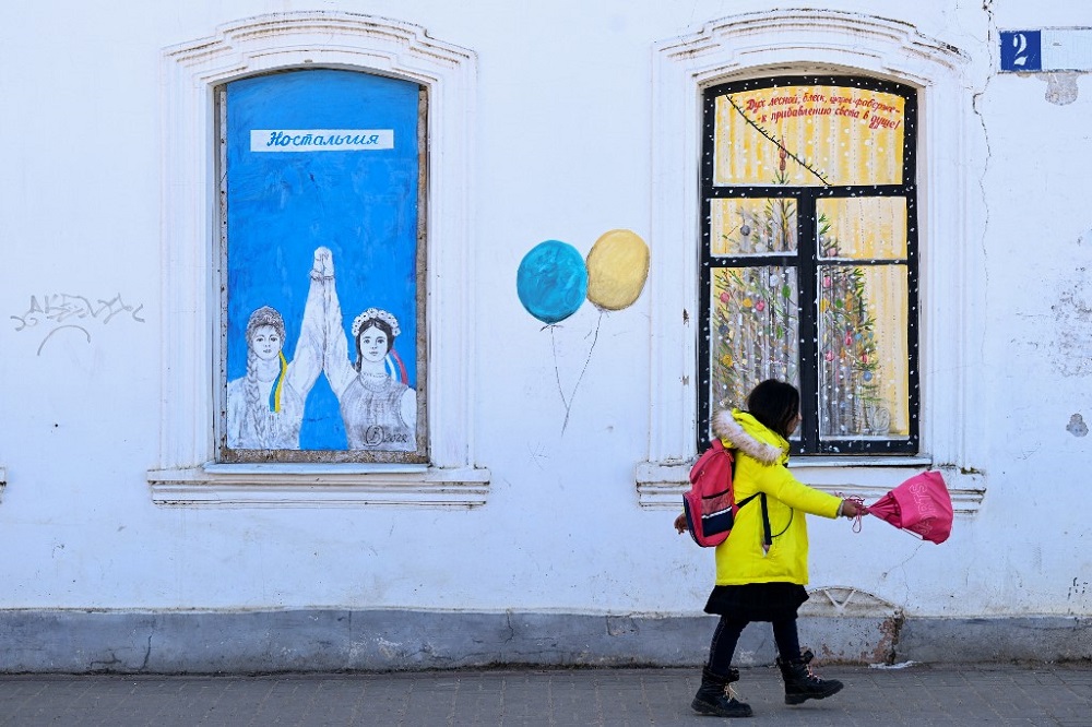 A child walks past by a graffiti made by the artist Vladimir Ovchinnikov in Borovsk, some 100kms south-west of Moscow April 14, 2022. u00e2u20acu201d AFP pic