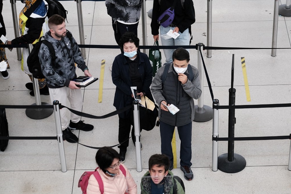 People with and without masks stand in a security line at John F. Kennedy Airport in New York April 19, 2022. u00e2u20acu201d AFP pic