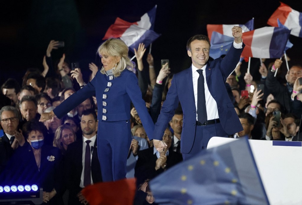 Emmanuel Macron (right) holds his fist in the air as he holds Brigitte Macronu00e2u20acu2122s hand after his victory in Franceu00e2u20acu2122s presidential election, at the Champ de Mars in Paris April 24, 2022. u00e2u20acu201d AFP picnn