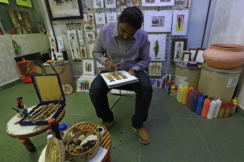Sudanese artist Mutaz al-Fateh paints with colours derived from natural material, at his gallery in Khartoum. u00e2u20acu201d AFP pic