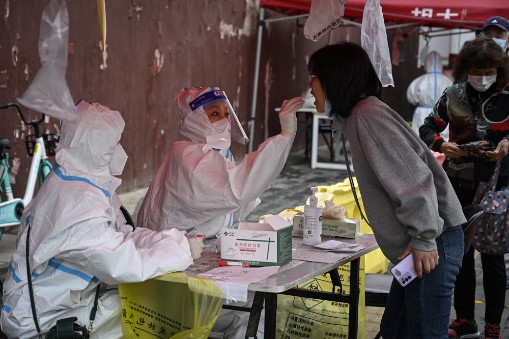 A health worker takes a swab sample from a woman to be tested for Covid-19 coronavirus at a makeshift testing site in Beijing April 27, 2022. u00e2u20acu201d AFP pic