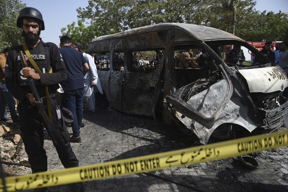 Police inspect a site around damaged vehicles following a suicide bombing near the Confucious Institute affiliated with the Karachi University, in Karachi on April 26, 2022. u00e2u20acu201d AFP pic