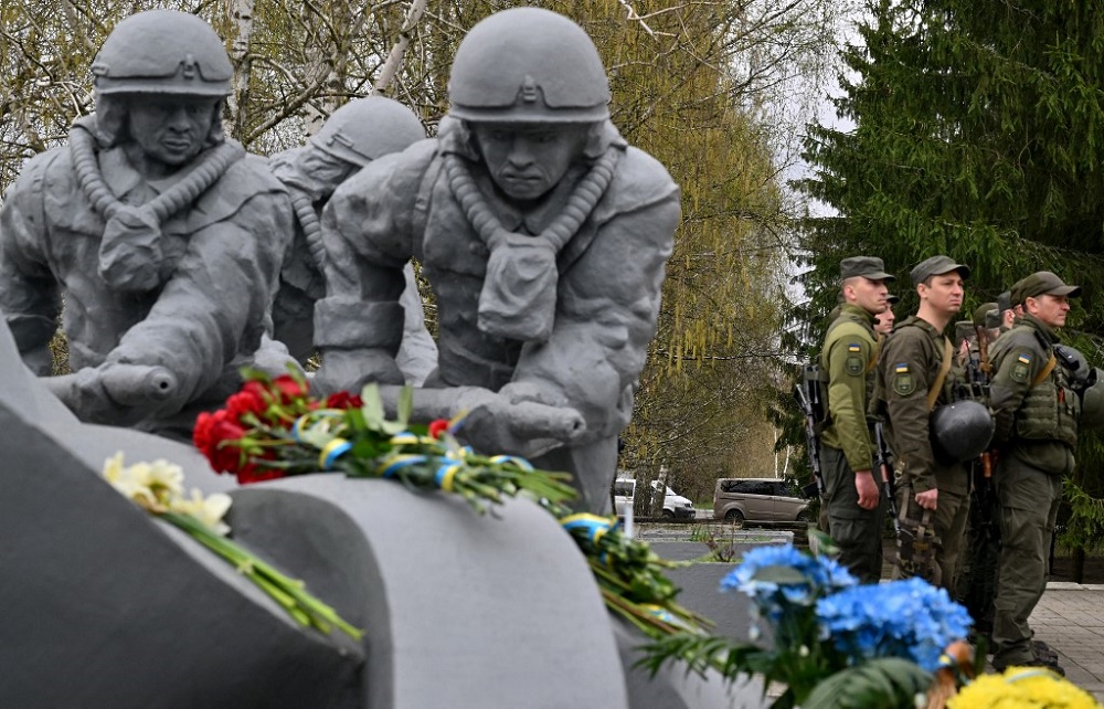 Ukrainian servicemen stand next to the monument in Chernobyl to pay tribute to the firefighters who died during 1986 Chernobyl disaster at the Chernobyl Nuclear Power Plant  April 26, 2022. u00e2u20acu201d AFP pic