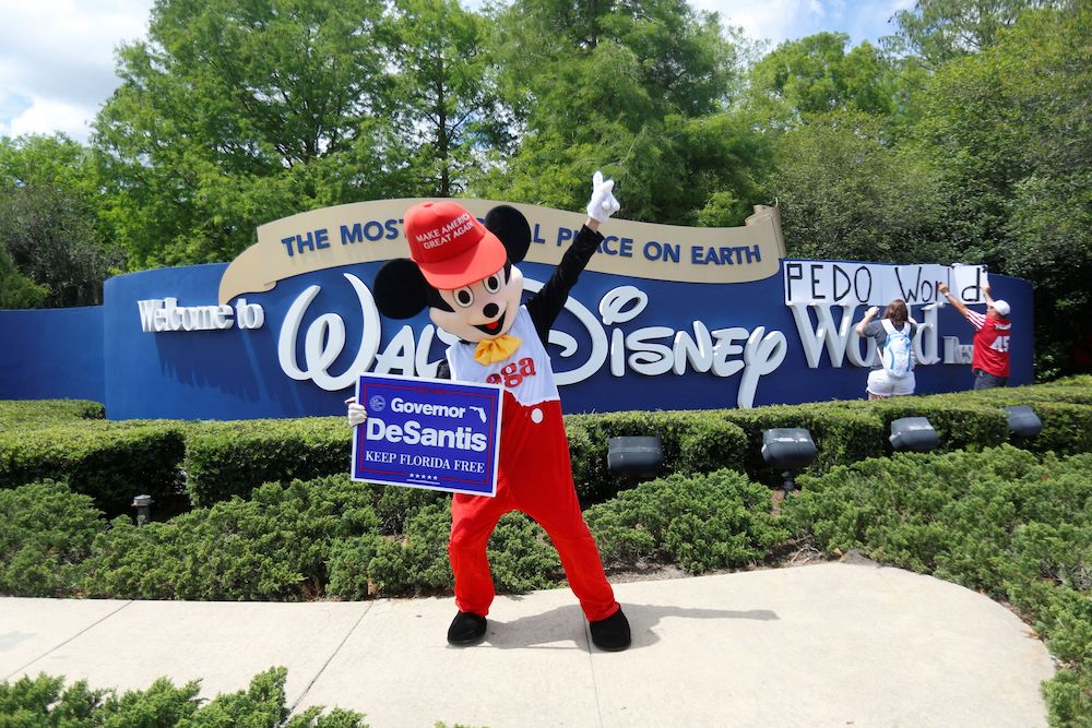 A person wearing a mouse costume dances while holding a Governor Ron DeSantis poster where supporters of Florida's Republican-backed u00e2u20acu02dcDon't Say Gayu00e2u20acu2122 bill gather for a rally outside Walt Disney World in Orlando, Florida April 16, 2022. u00e2u20acu201d Reuters pic