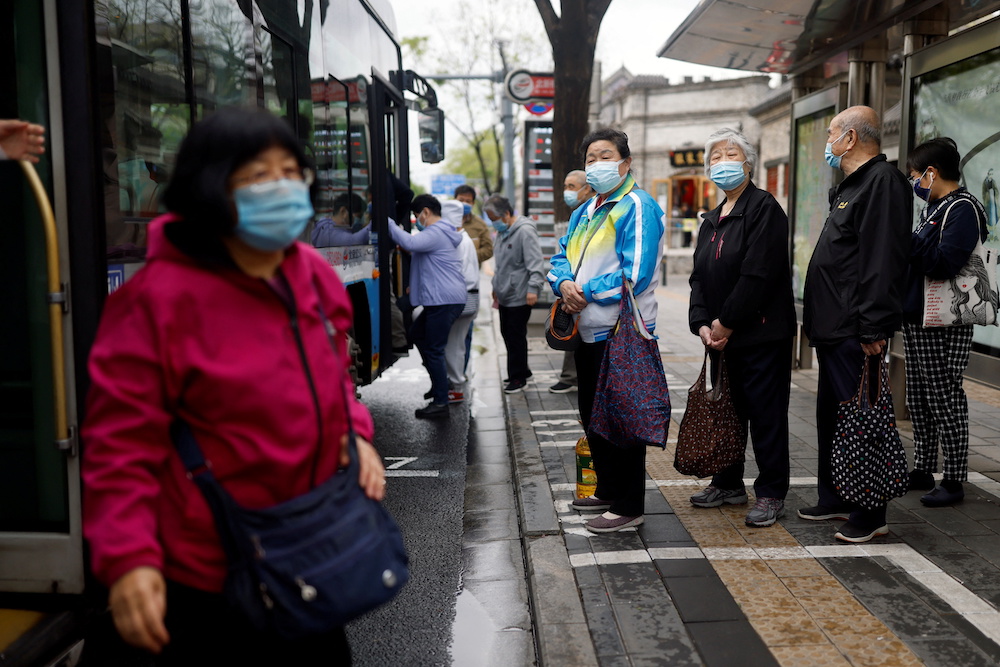 Commuters wearing face masks wait at a bus station amid the Covid-19 outbreak in Beijing, China April 28, 2022. u00e2u20acu201d Reuters pic