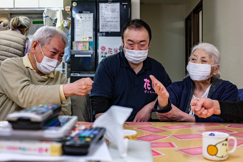 This picture taken on March 30, 2022 shows retired sumo wrestler and staff member Shuji Nakaita taking care of elderly people at the Hanasaki daycare centre in Tokyo. — AFP pic