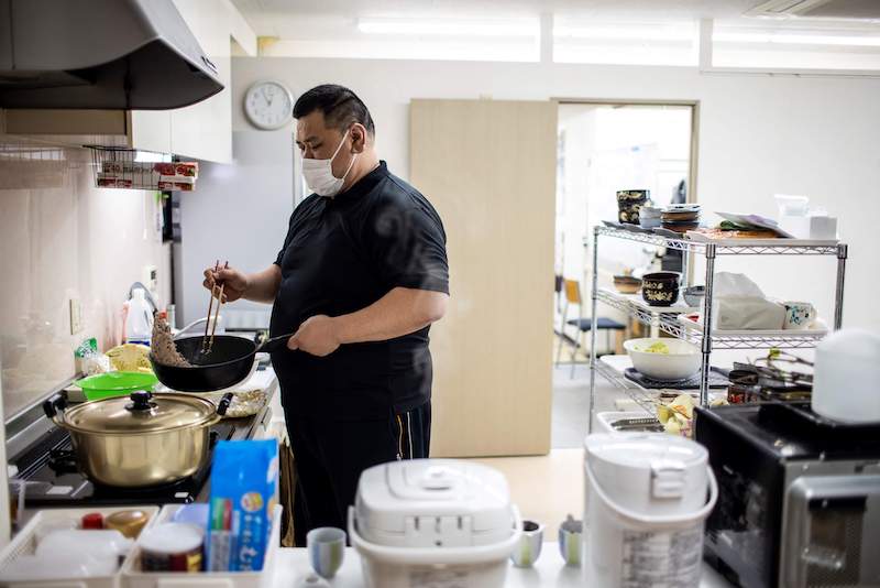 This picture taken on April 6, 2022 shows retired Japanese sumo wrestler and owner of the Hanasaki daycare centre, Keisuke Kamikawa, preparing food for elderly people at the centre in Tokyo. u00e2u20acu201d AFP pic