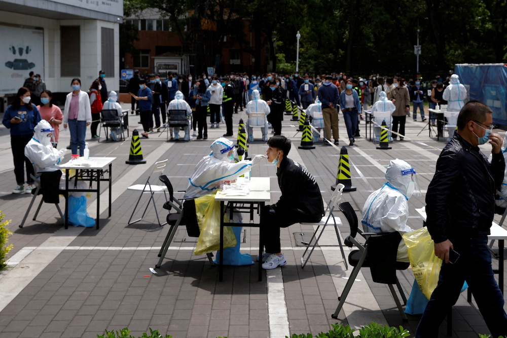 A medical worker in a protective suit collects a swab sample from a resident at a makeshift nucleic acid testing site amid the Covid-19 outbreak in Beijing, China April 28, 2022. u00e2u20acu201d Reuters pic
