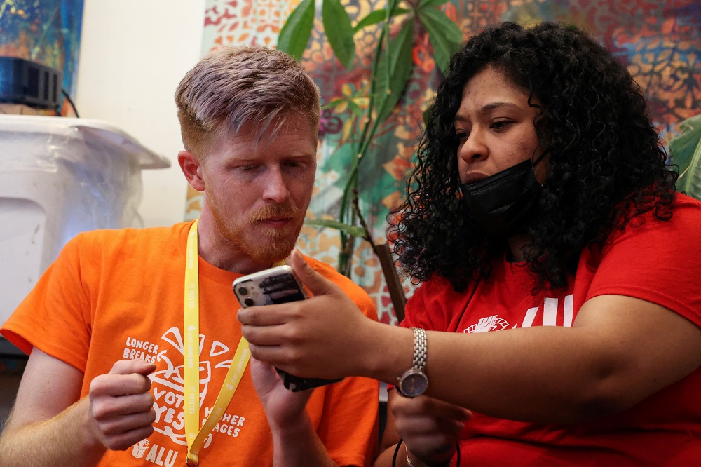 Angelika Maldonado, Chairwoman of the Amazon Labour Union Workers Committee, and Brett Daniels, Director of Organising for the Workers Committee of Amazon Labour Union chat as they watch the NLRB count the votes to unionise in Brooklyn, New York March 31,