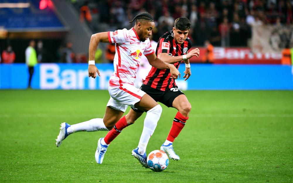 Leipzig midfielder Christopher Nkunku and Leverkusen defender Piero Hincapie vie for the ball during the German first division Bundesliga match in Leverkusen, western Germany, April 17, 2022. u00e2u20acu201d AFP picnn