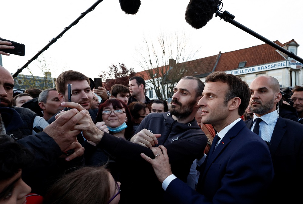 French President Emmanuel Macron meets with supporters during his first campaign day trip after coming first in the first round of the 2022 French presidential election, in Carvin, France April 11, 2022. u00e2u20acu2022 Pool via Reuters
