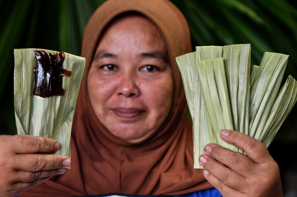 Rojini Razak poses with freshly made u00e2u20acu02dcdodol daun palasu00e2u20acu2122 during an interview at Kampung Batangan in Marang April 6, 2022. u00e2u20acu201d Bernama pic