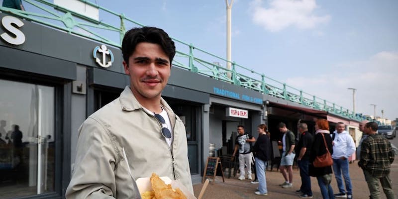 A customer shows off his fish and chips lunch outside Captainu00e2u20acu2122s Fish and Chips shop in Brighton. u00e2u20acu201d ETX Studio picnn