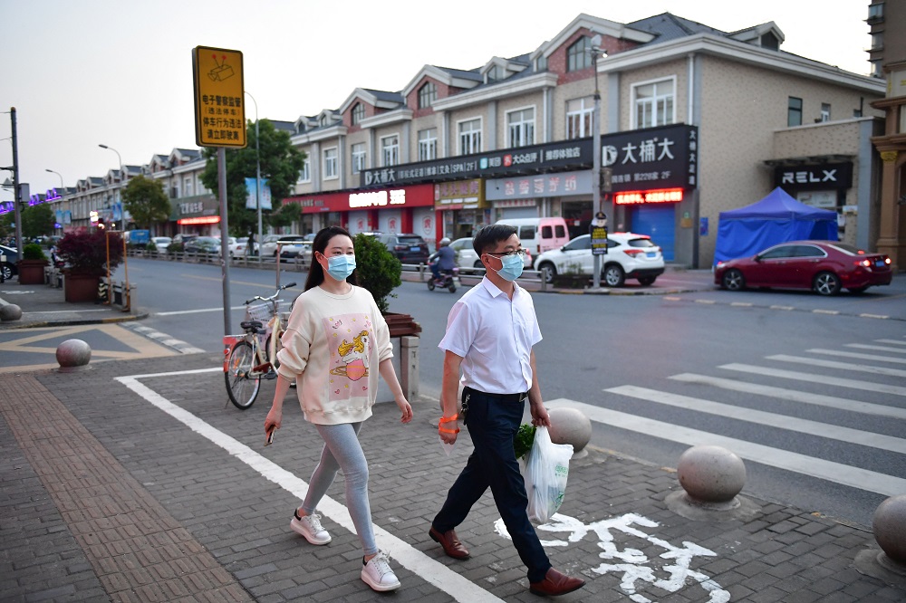 Residents walk on a street in Fengjing town of Jinshan district, Shanghai, China April 11, 2022. u00e2u20acu2022 cnsphoto via Reuters