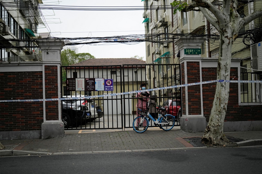 A resident stands behind a gate blocking an entrance to a residential area under lockdown amid the Covid-19 pandemic, in Shanghai, China April 13, 2022. u00e2u20acu2022 Reuters pic