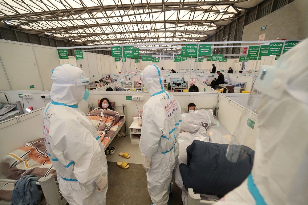 Medical workers in protective suits conduct ward rounds at Shanghai New International Exhibition Hall, which has been turned into a makeshift hospital for Covid-19 patients, in Shanghai, China April 9, 2022. u00e2u20acu2022 China Daily via Reuters