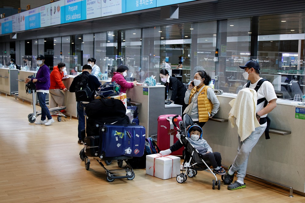 People wearing face masks wait to check in at Incheon International Airport, in Incheon, South Korea March 25, 2022. u00e2u20acu2022 Reuters file pic