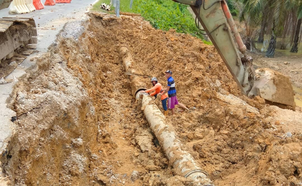 The Rural Water Supply Department (JBALB) contractors repairing the burst pipe caused by slope failure that forced unscheduled water supply disruption in Beluru district. u00e2u20acu201d Borneo Post pic