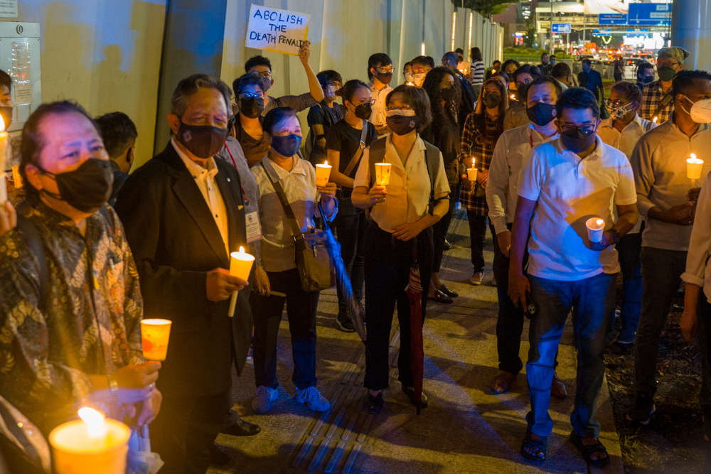 The vigil began at 8.30pm when around 40 people walked from the side entrance of the Singapore embassy holding makeshift candle holders made out of plastic cups. — Picture By Devan Manuel