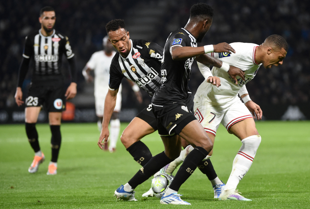 Paris Saint-Germain forward Kylian Mbappe fights for the ball with Angers defender Abdoulaye Bamba (centre) during the French L1 match at the Raymond-Kopa Stadium in Angers, north-western France, April 20, 2022. u00e2u20acu201d AFP pic 