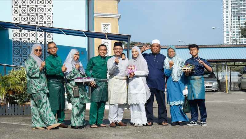 Newlywed Aliff Maaruf Halimi along with his wife and their families during their big day last February. — Picture courtesy of Aliff Maaruf Halimi