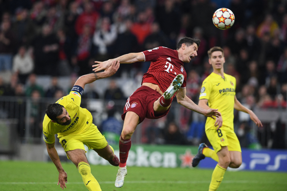 Bayern Munich forward Robert Lewandowski and Villarreal defender Raul Albiol vie for the ball during the Uefa Champions League quarter-final, second leg match in Munich, southern Germany, April 12, 2022. u00e2u20acu201d AFP picnn