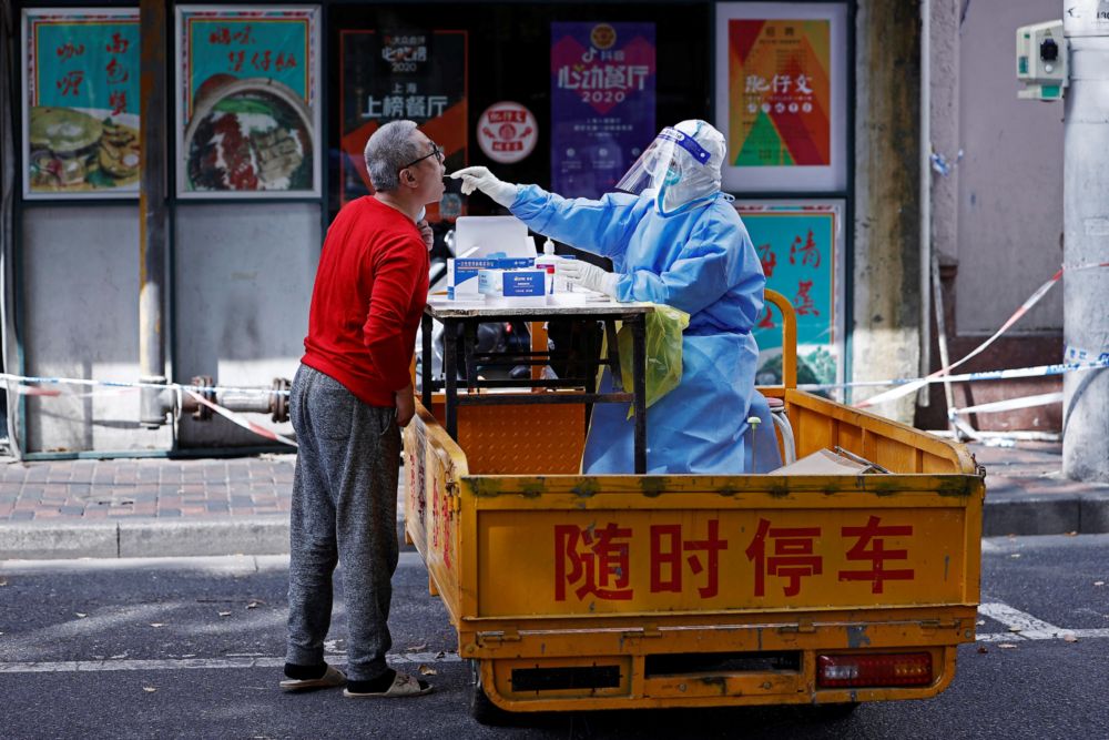 A medical worker in a protective suit collects a swab from a resident for nucleic acid testing, amid the coronavirus disease (Covid-19) outbreak in Shanghai, China April 22, 2022. u00e2u20acu201d cnsphoto via Reuters