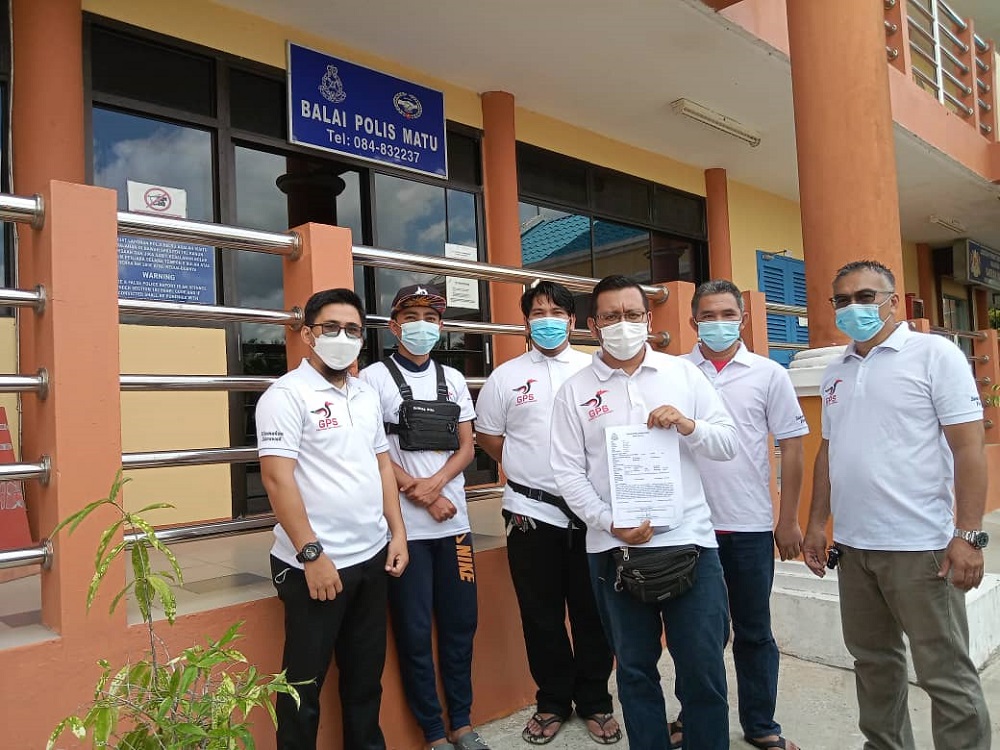 Hafiz (third right) shows the police report. u00e2u20acu201d Picture by Mohamad Achil Norlatep via Borneo Post Online