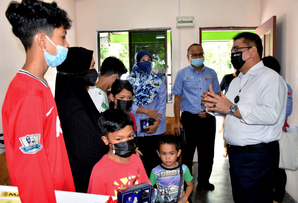 Melaka Chief Minister Datuk Seri Sulaiman Md Ali speaks to Yusriati Mohd Yunos, 42, the widow of late Melaka United player Mohd Azizan Baba, after presenting Socso benefits to the family in Melaka, April 6, 2022. u00e2u20acu201d Bernama pic 