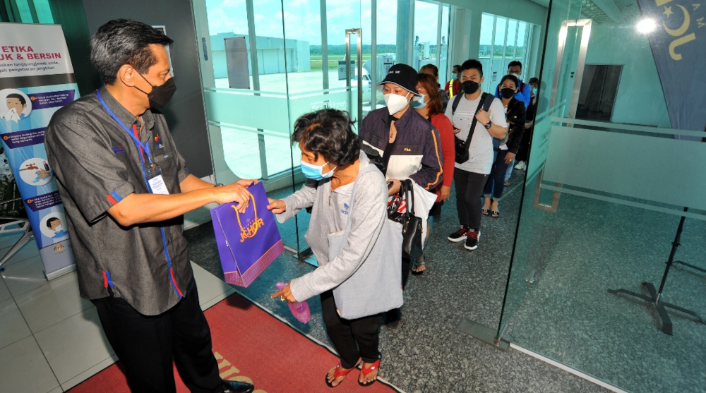 A Tourism Johor official welcomes the arrival of the first international flight at the Senai International Airport (LTAS) in Senai, Kulai April 1, 2022. u00e2u20acu201d Picture by Ben Tan